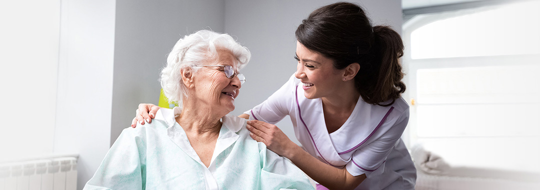 A nurse smiling with an elderly woman