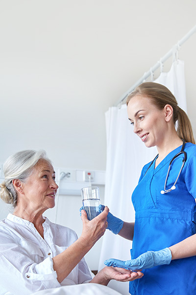 yolo-400x600-69b A nurse giving an elderly woman medicine